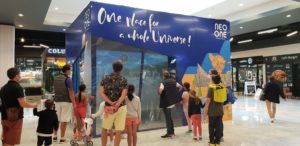 Arène immersive avec murs interactifs et projection animée dans un centre commercial, enfants et parents participants.