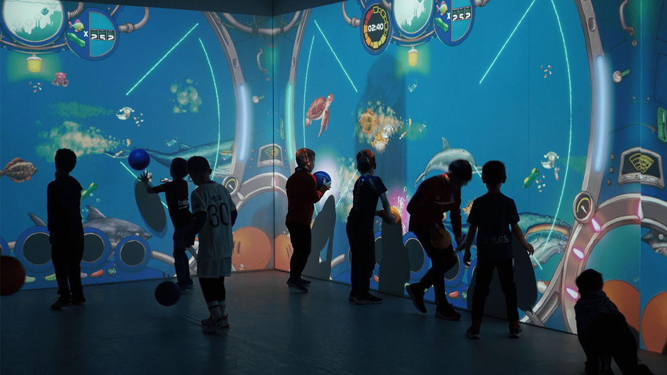 Enfants jouant à un jeu aquatique sur des murs interactifs immersifs dans une salle de jeu immersive