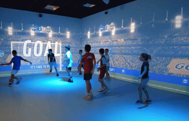 Groupe d'enfants jouant dans le Digital Stadium au football