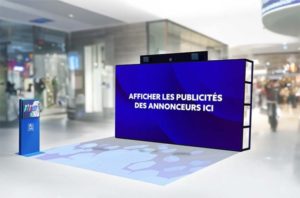 Mur interactif dans un centre commercial diffusant des publicités digitales aux passants.
