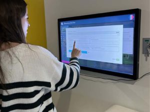Woman using the NeoXperiences remote screen to programme a session on the Neo-One interactive wall