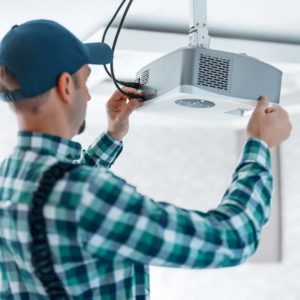 Man installing a video projector on the ceiling
