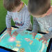 Two children play a fishing game on the Neo GameBoard S interactive digital table from NeoXperiences