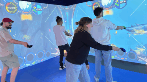 Four people playing an interactive game on the Neo-Pad mixed reality wall in an immersive room