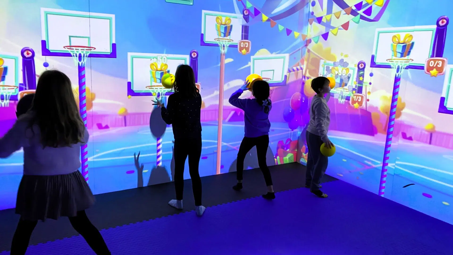 Enfants jouant au basket lors de l'expérience immersive Birthday Xperiences, salle interactive avec jeux sportifs et décor thématique